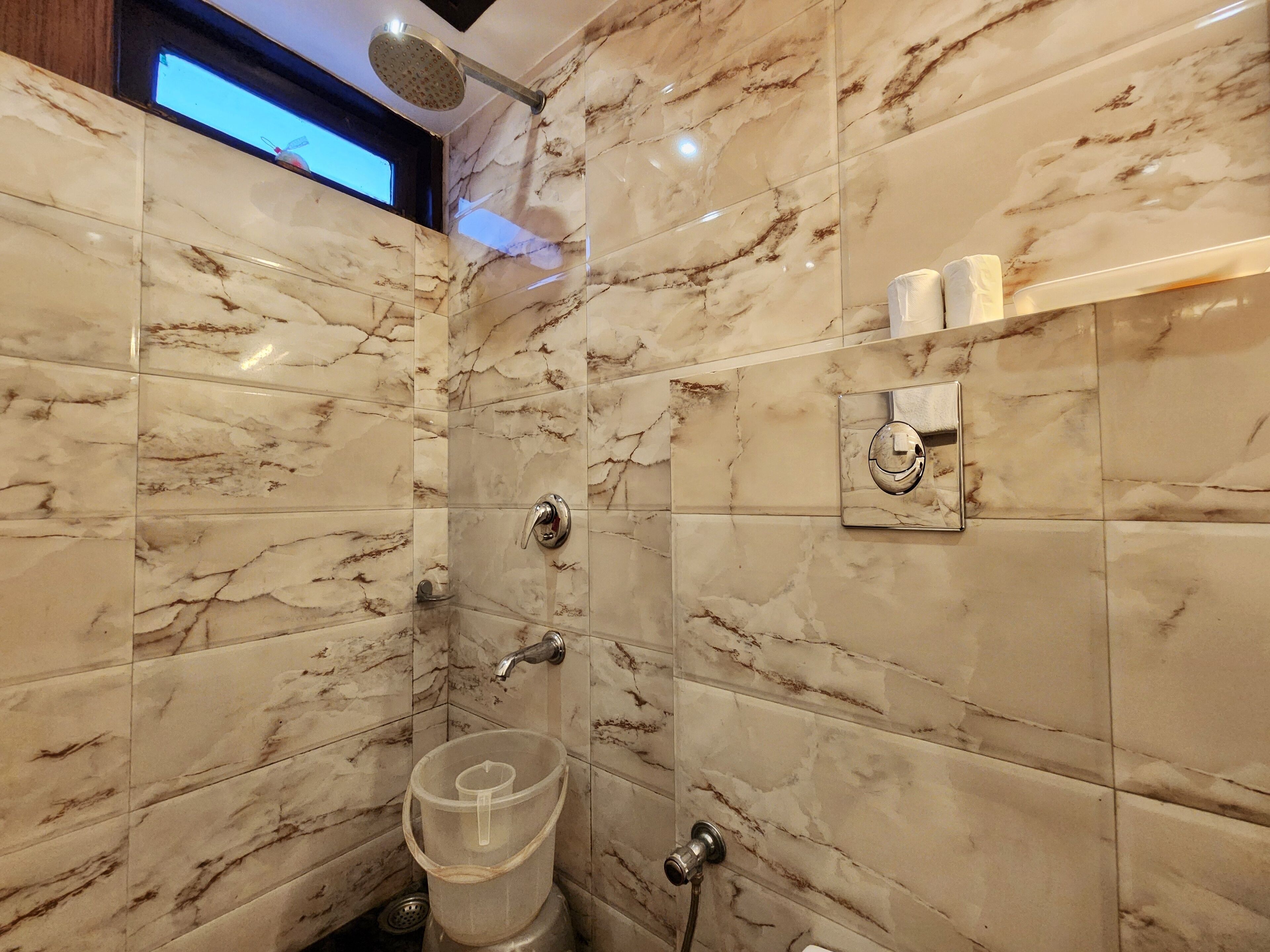 Un bagno con pareti in marmo, una doccia, un water e un bidet.