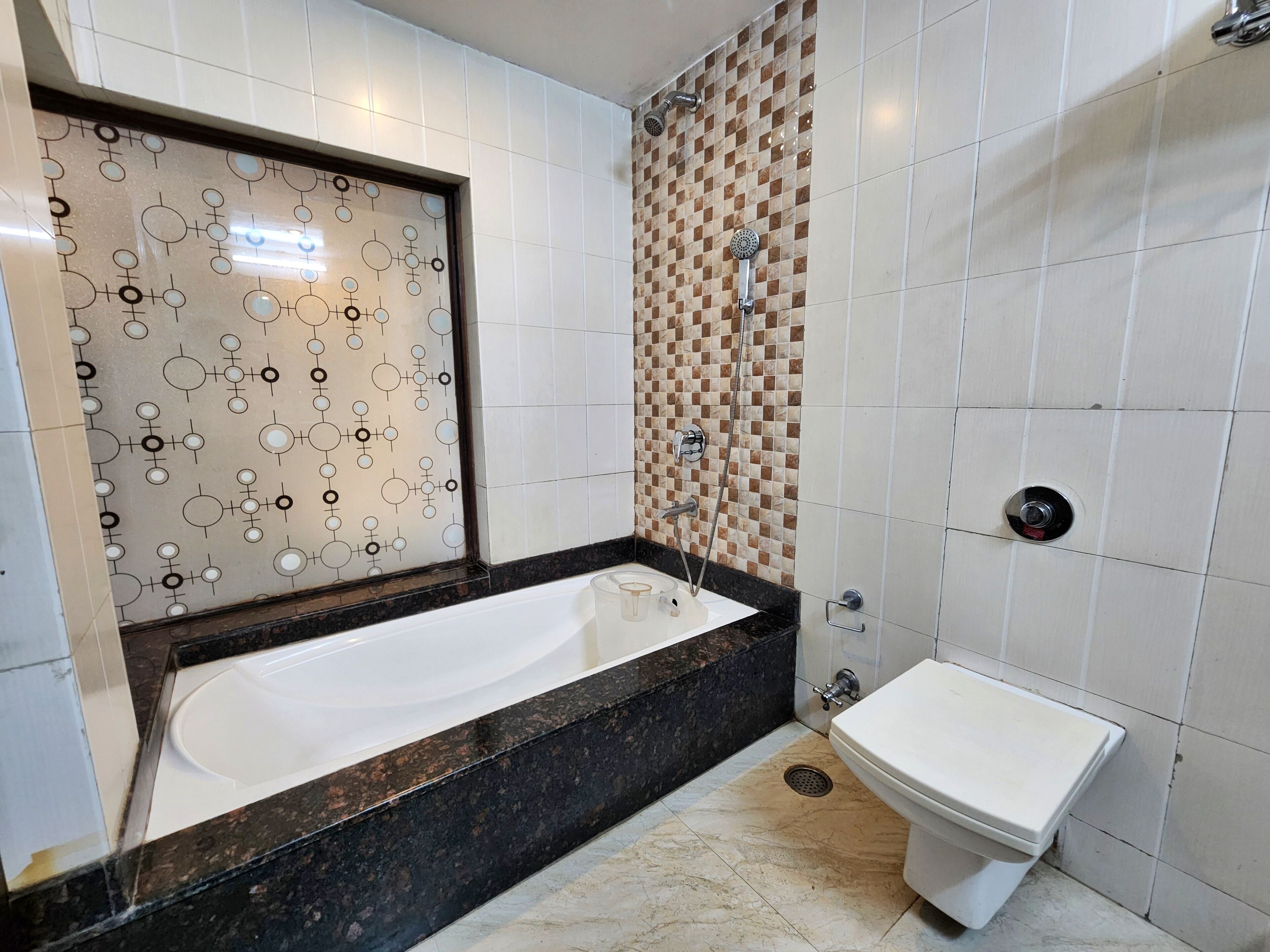 A modern bathroom with a large bathtub, a separate sink, and a shower area.
