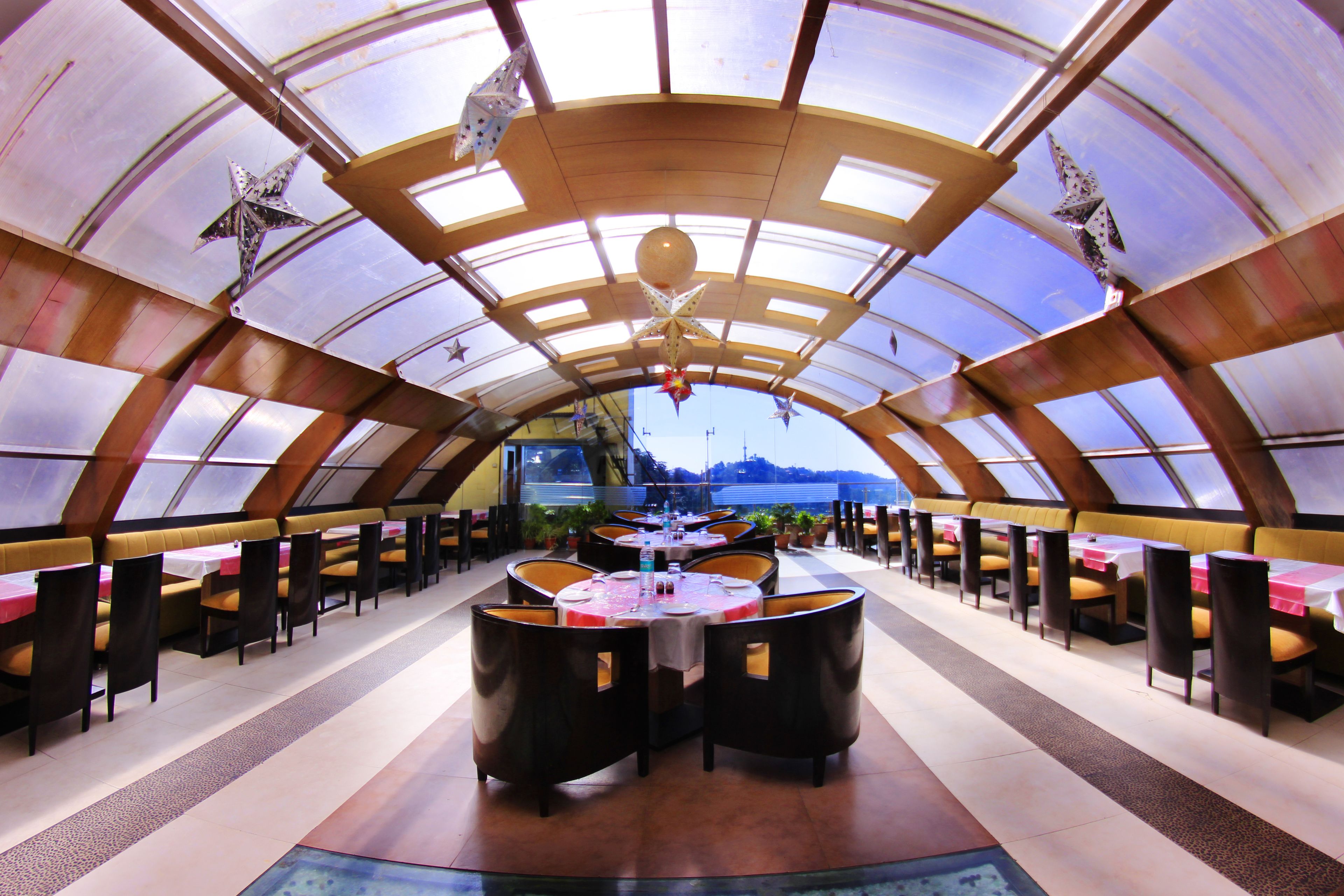 A restaurant with a high, arched ceiling and multiple tables and chairs.