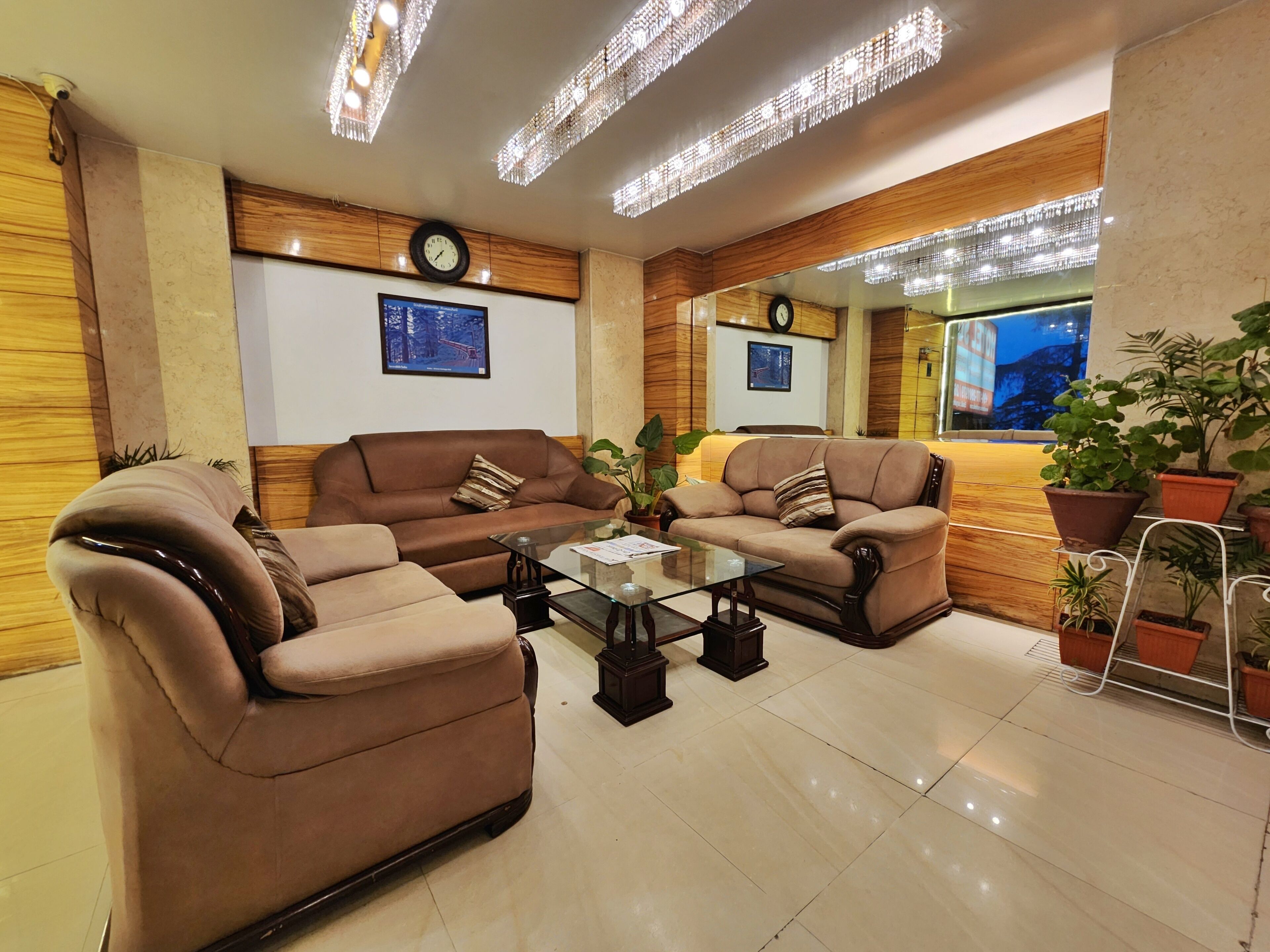 A modern living room with two sofas, a glass coffee table, and decorative lighting.