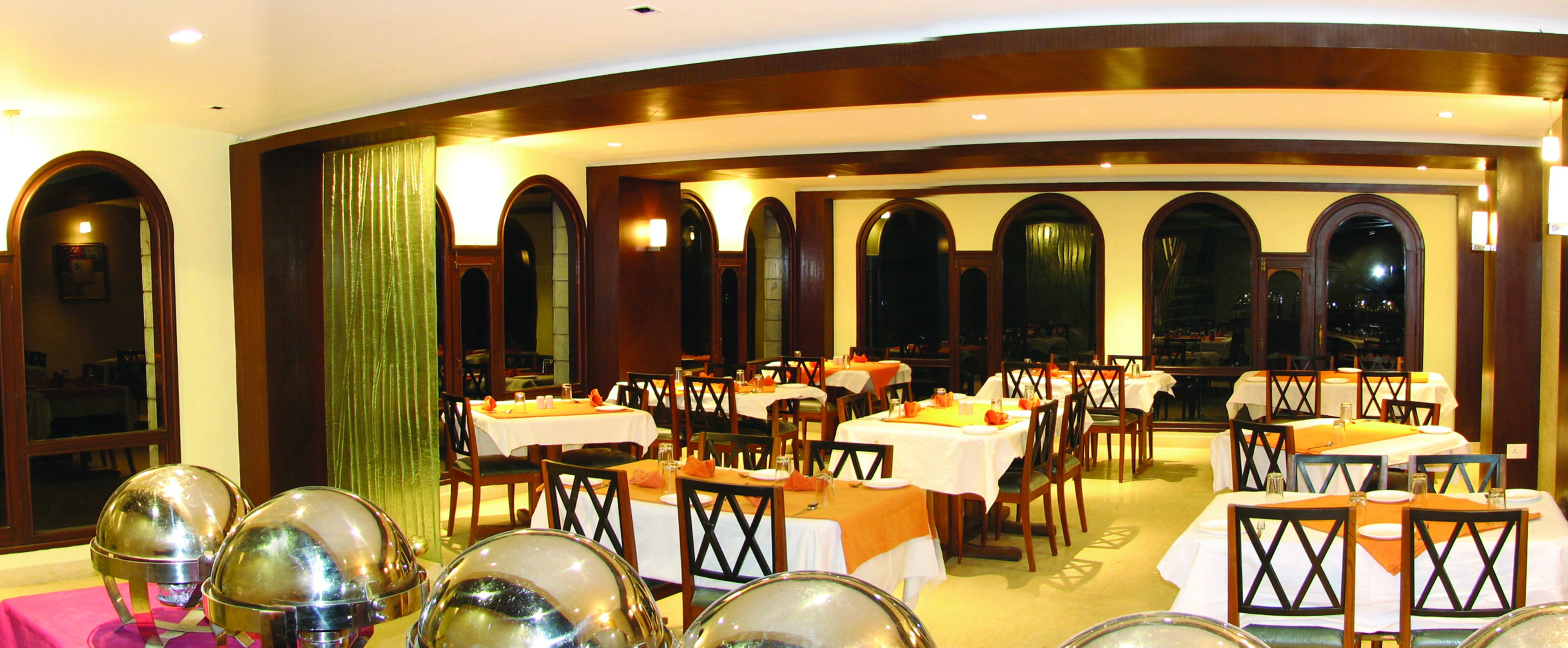 A dining area with multiple tables and chairs, arranged in a semi-circular layout.