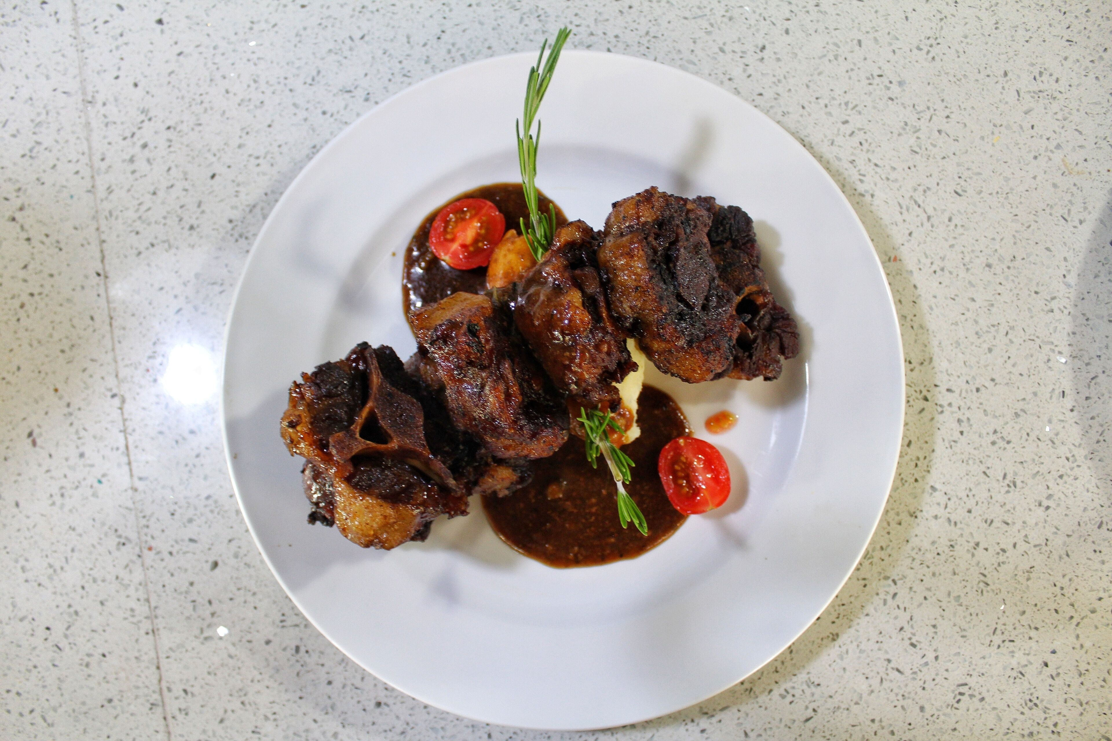 A plate of food with meat and vegetables on a white plate.