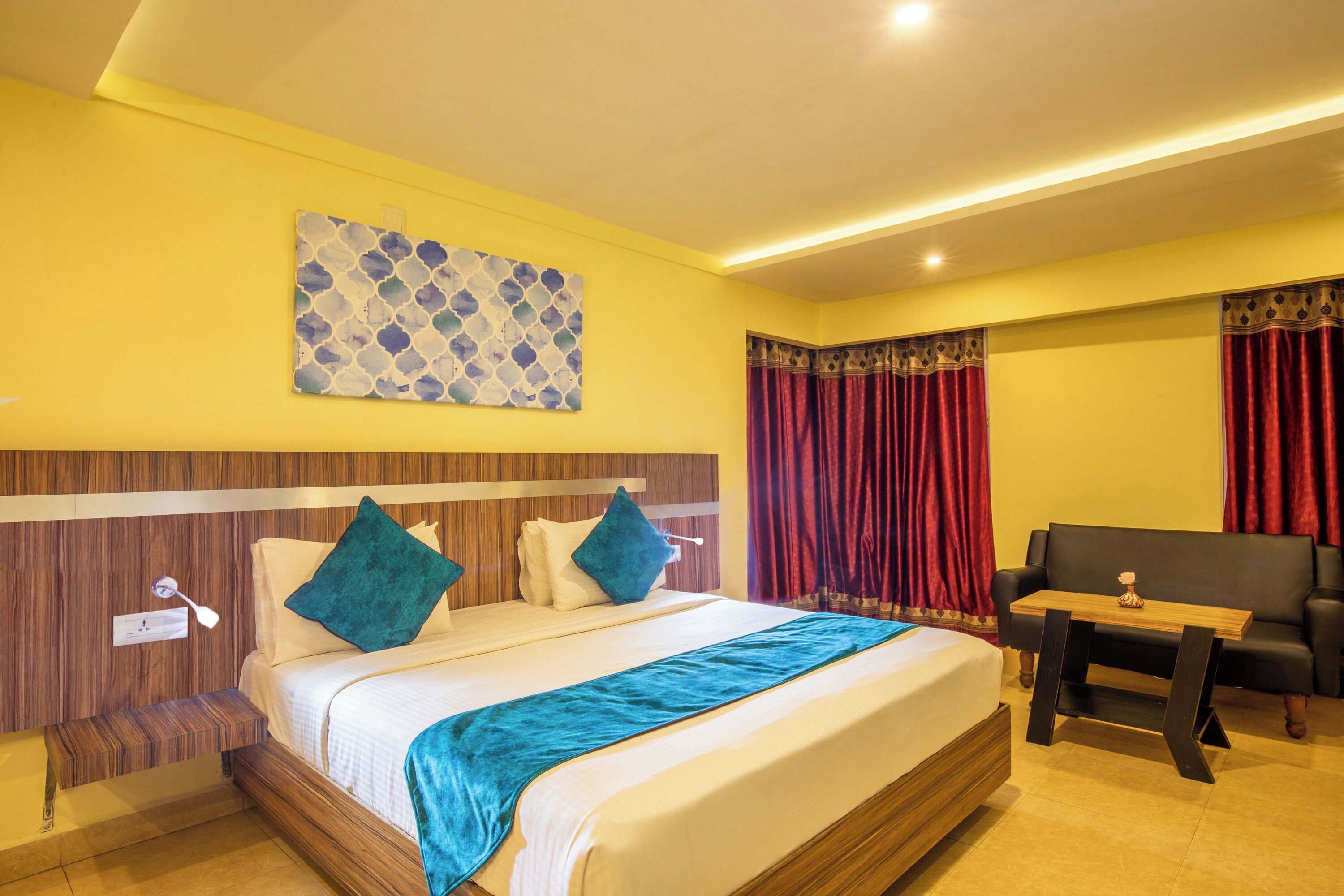 Ein Hotelzimmer mit Bett, Nachttisch, Schreibtisch und einer Couch.