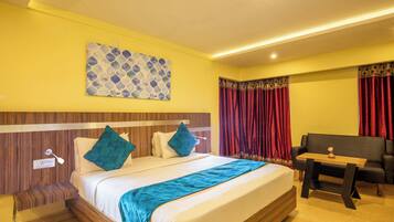 Ein Hotelzimmer mit Bett, Nachttisch, Schreibtisch und einer Couch.