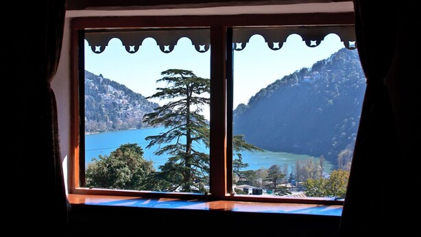 Una ventana con vistas a un paisaje montañoso y un cuerpo de agua.