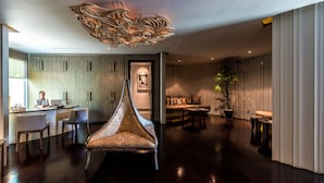 A spacious living area with a modern sofa, a unique chair, and a dining area with a counter. - Club Wyndham Patong Hill Phuket, Trademark Collection by Wyndham (Patong)