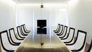 A conference room with a long table, chairs, a television, and a window with blinds. - Club Wyndham Patong Hill Phuket, Trademark Collection by Wyndham (Patong)