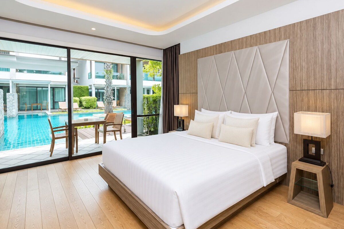 Una habitación de hotel moderna con una cama grande, vistas a una piscina y un balcón.