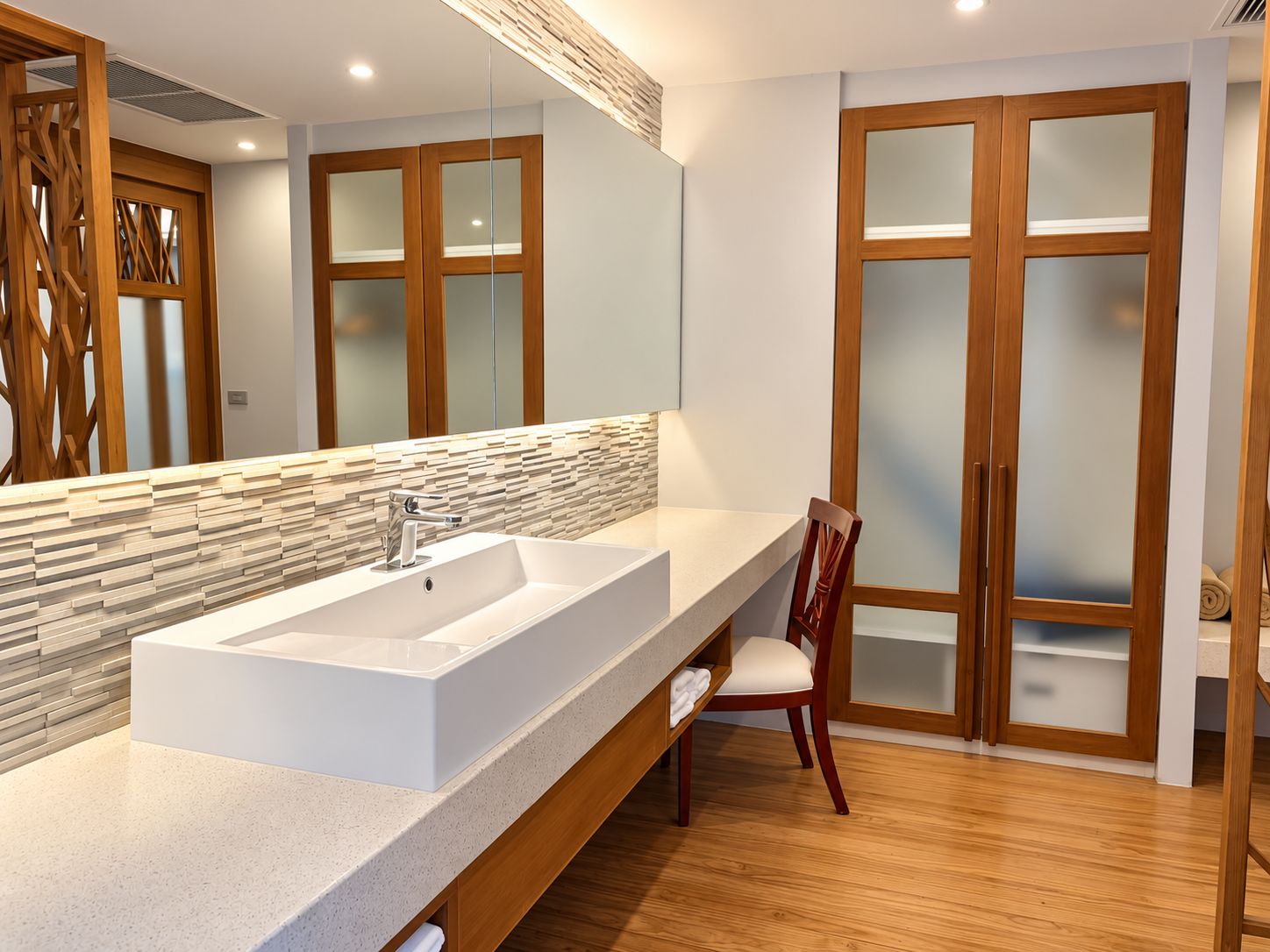 Un baño moderno con un lavamanos grande, un armario de madera y un espejo.
