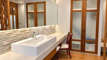 Un baño moderno con un lavamanos grande, un armario de madera y un espejo.