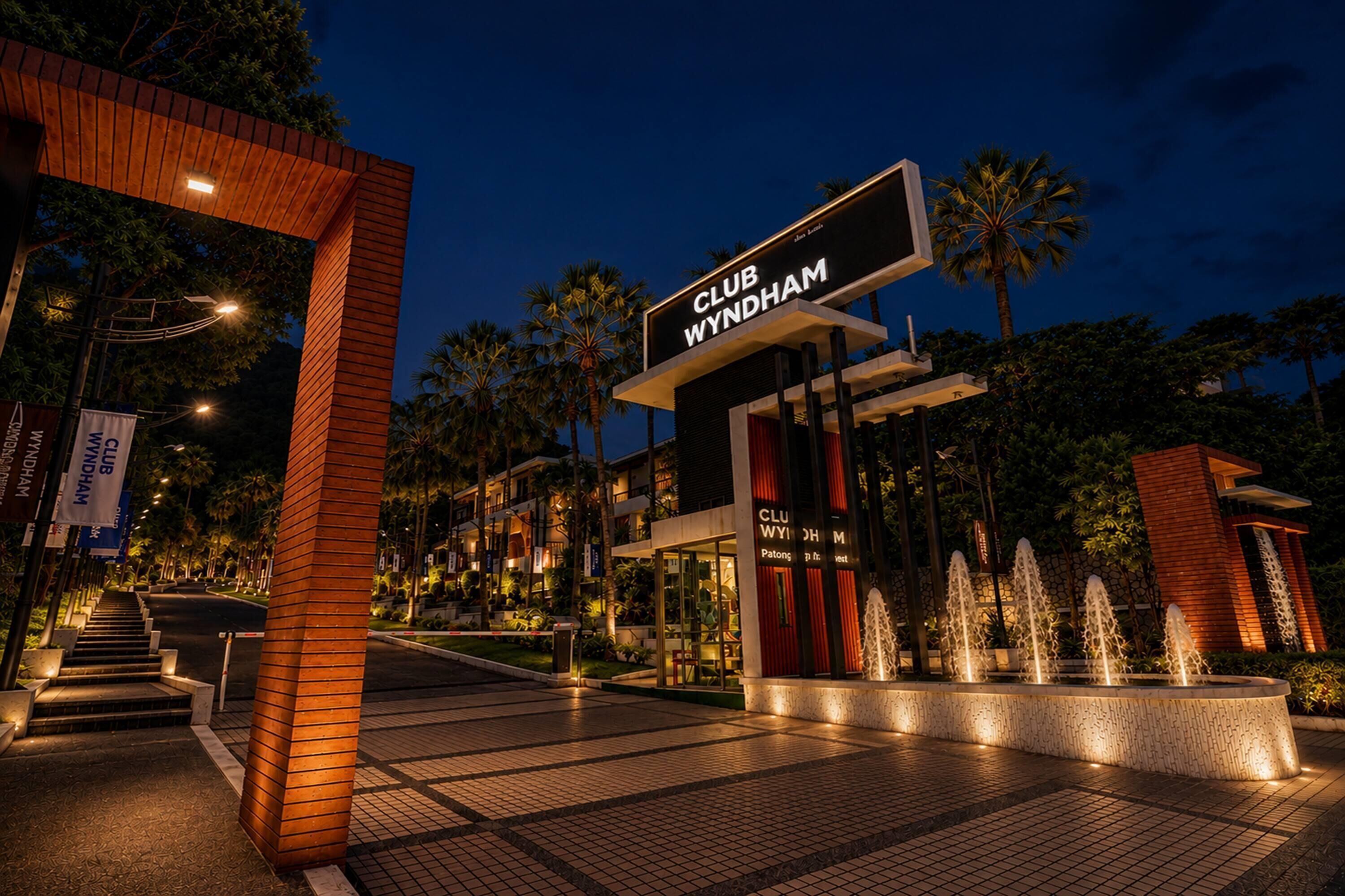 A Club Wyndham entrance with a modern design, palm trees, and a well-lit pathway leading to the building.
