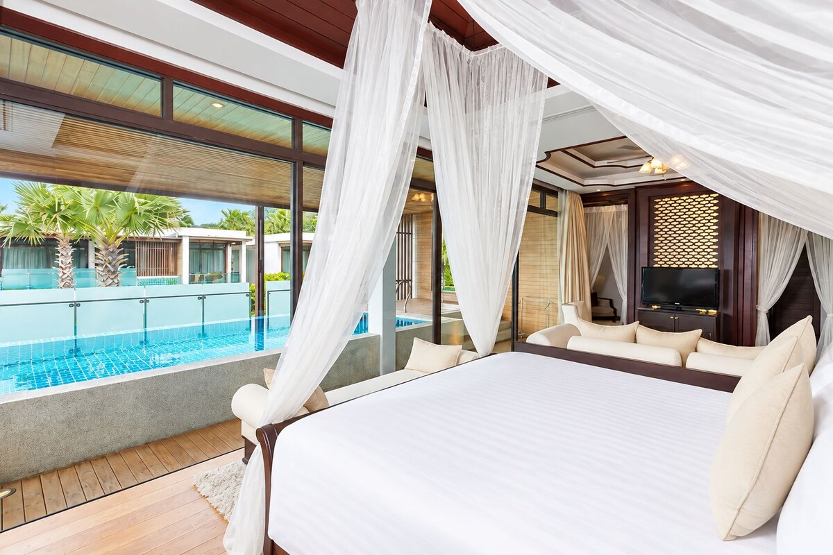 Un dormitorio con una cama grande, un televisor y vistas a una piscina.