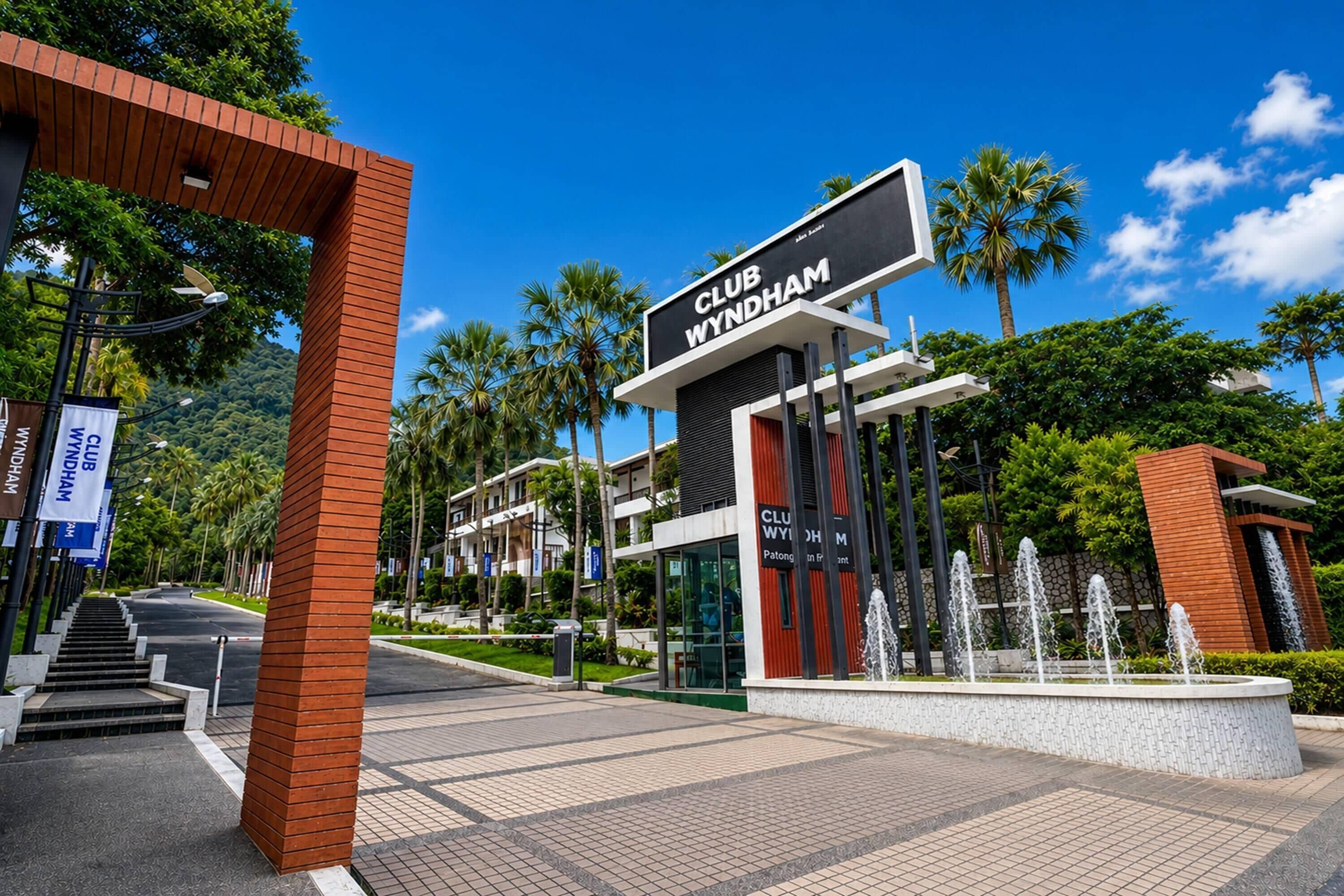 A modern building with a sign reading 'CLUB WYNDHAM' and a water feature in front.