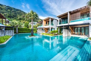A modern resort with a swimming pool, multiple-story buildings, and lush greenery.