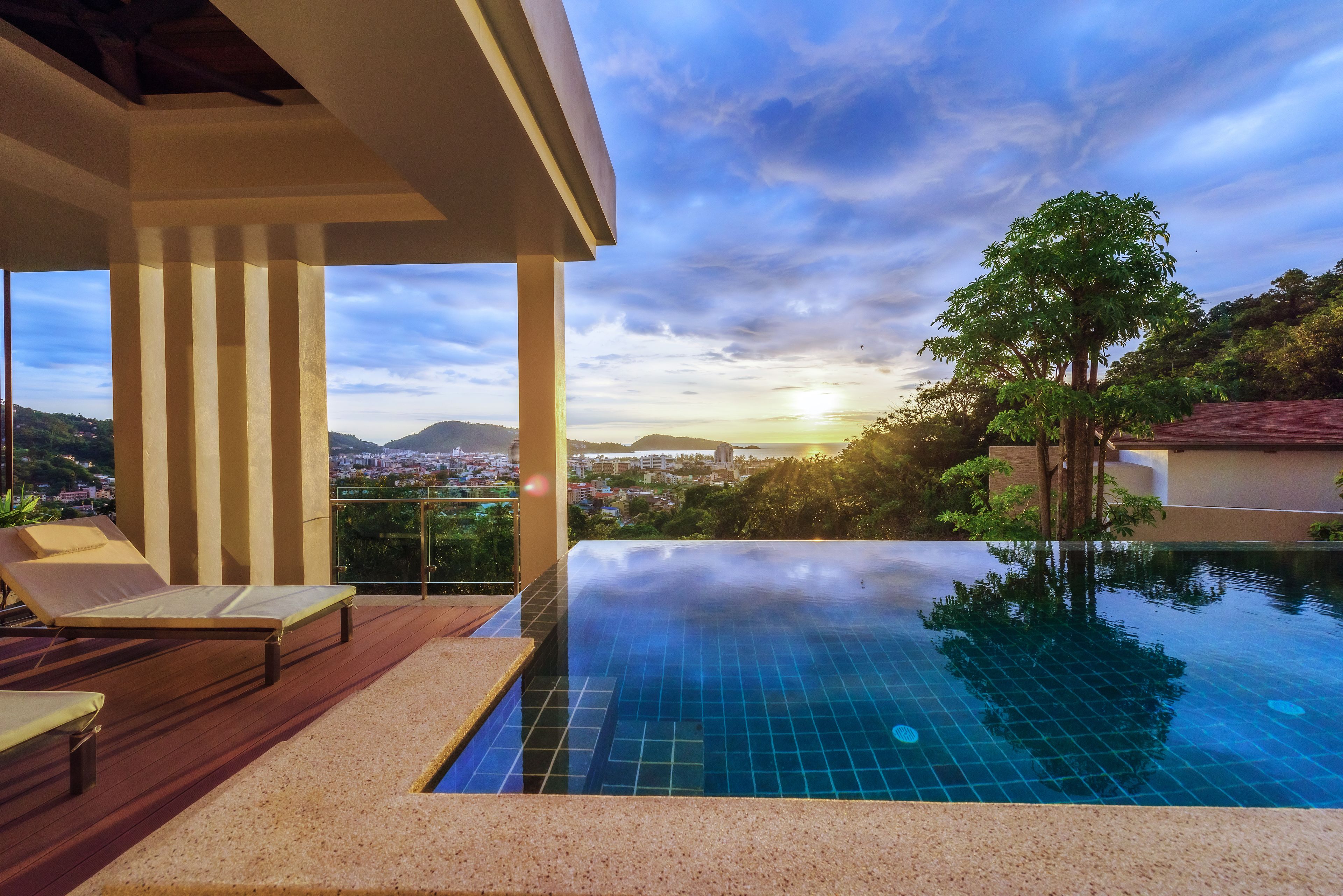 An infinity pool with a clear view of a cityscape and mountains in the background.