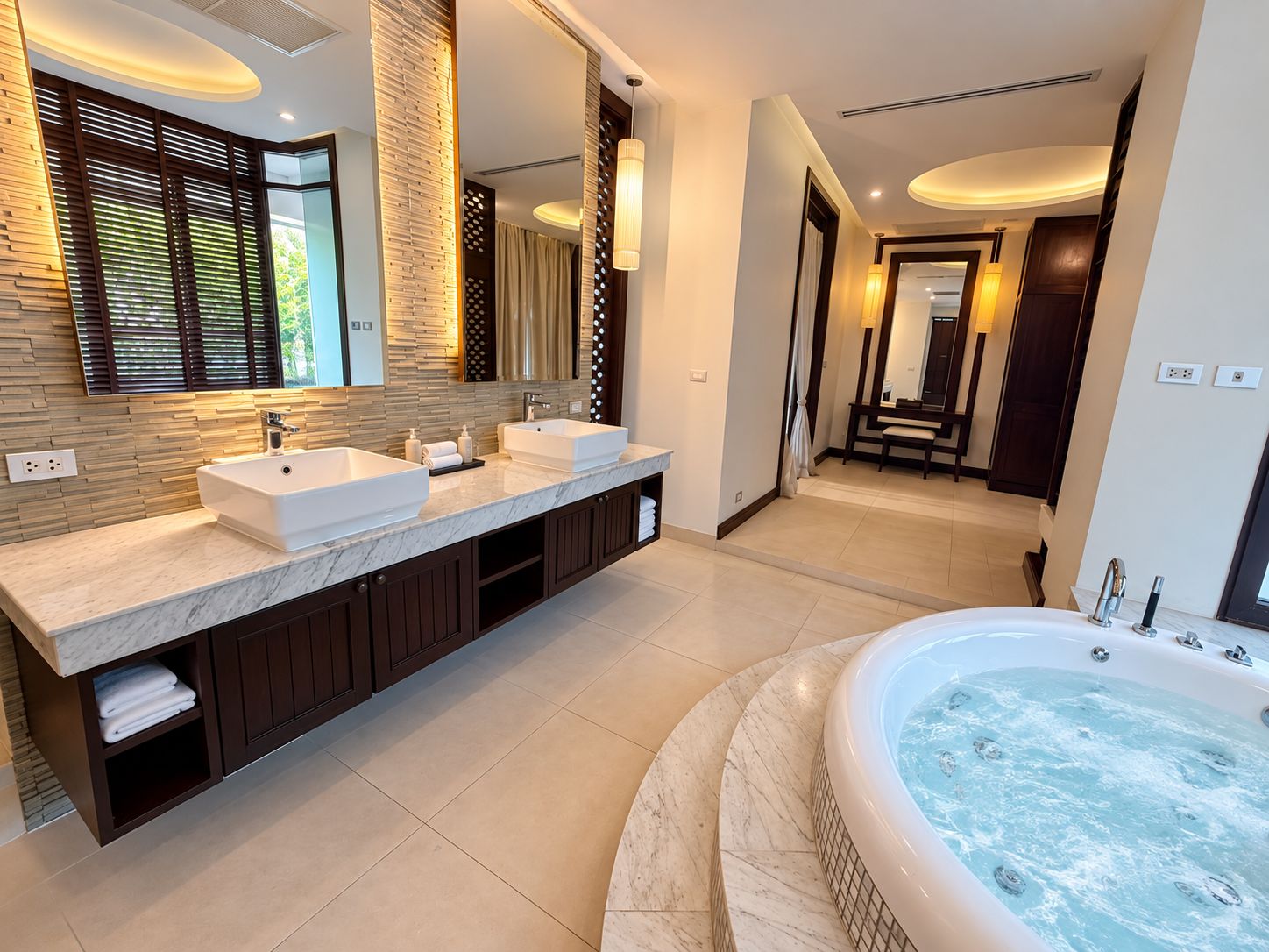 A modern bathroom with a double sink vanity, a large bathtub, and a walk-in shower.