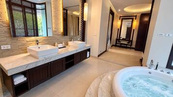 A modern bathroom with a double sink vanity, a large bathtub, and a walk-in shower.