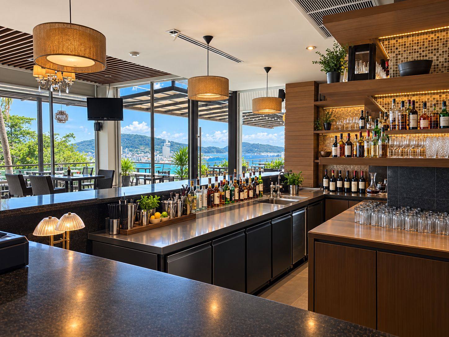 A modern bar with a view of the sea, a variety of bottles, and a large window.