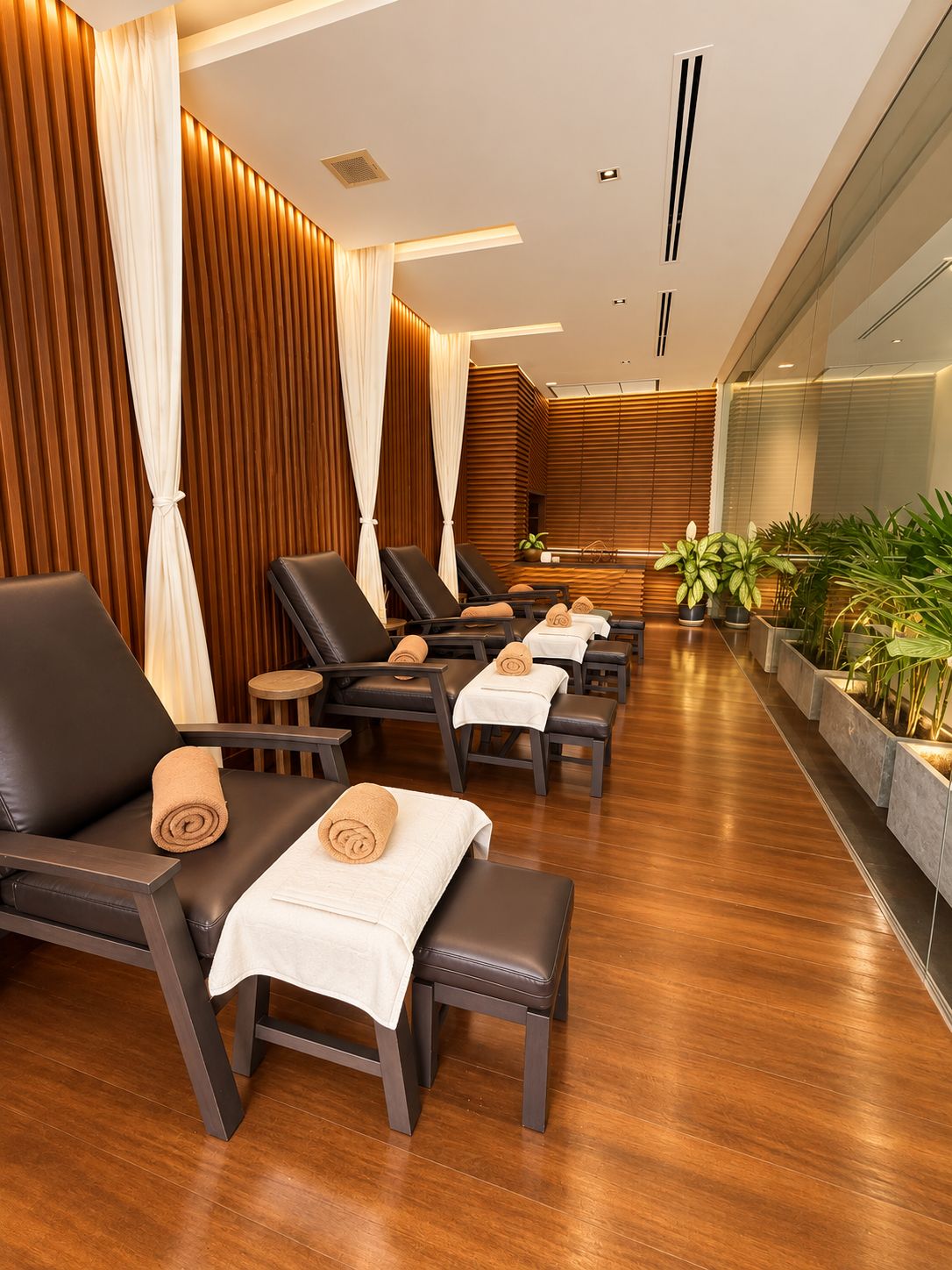 A spa area with multiple massage chairs, each with a towel and a small table.
