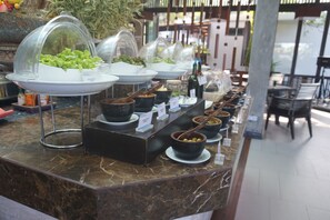 Enjoy a diverse selection of food options at our buffet, featuring a variety of dishes in bowls and covered containers.