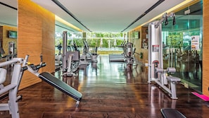 A modern gym with various exercise equipment, large windows, and a wooden floor. - Club Wyndham Patong Hill Phuket, Trademark Collection by Wyndham (Patong)
