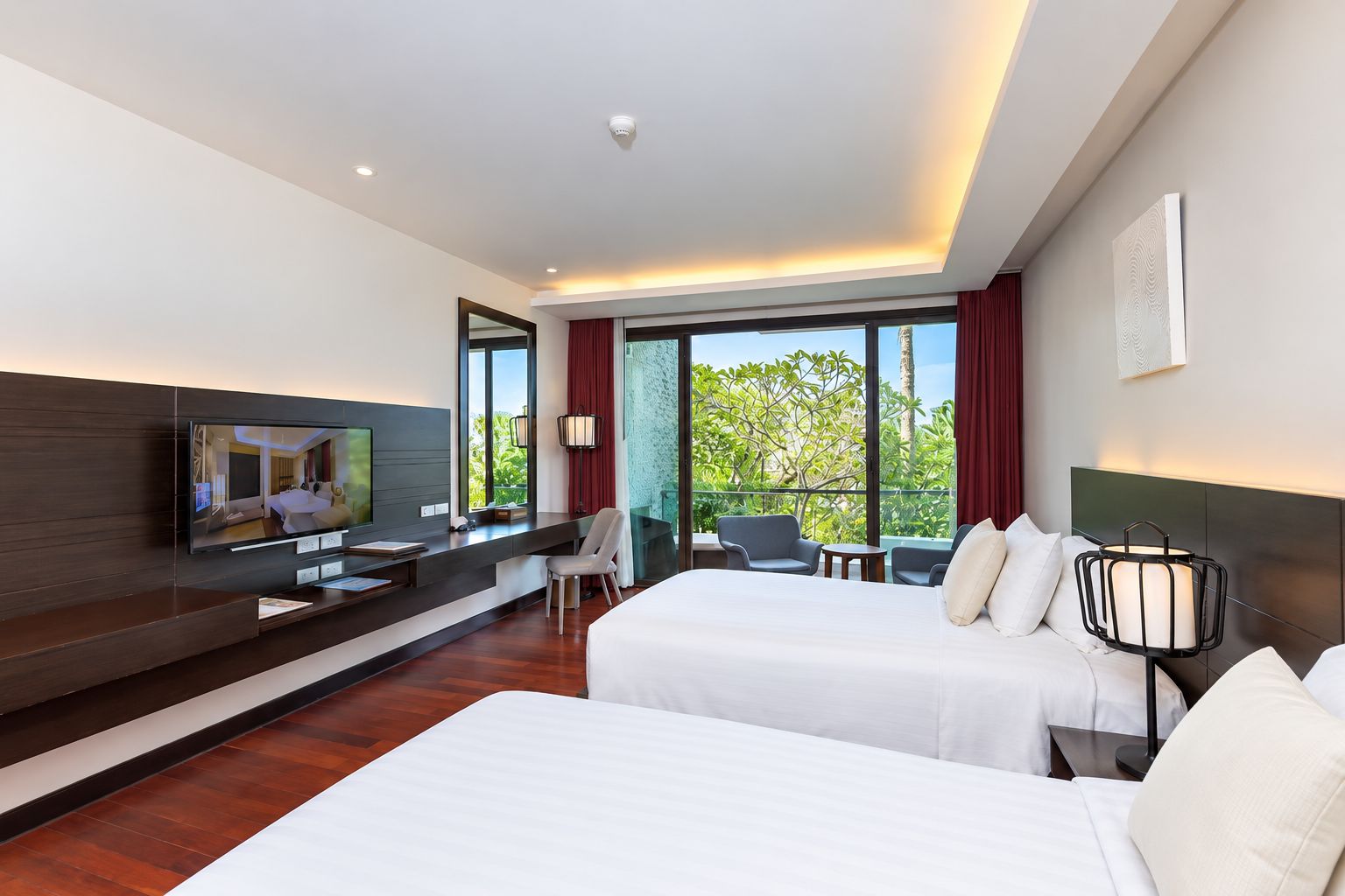 A hotel room with a bed, a desk, a TV, and a view of the outdoors.