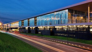 Een modern hotel met een glazen gevel, een ruime lobby en een goed verlichte buitenkant.