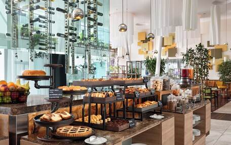 A buffet with various baked goods, pastries, and fruits.