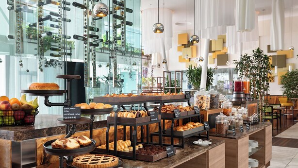 Een buffet met diverse gebakjes, patisserie en fruit.