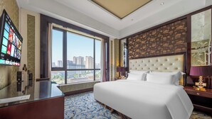 A hotel room with a large bed, a desk, and a view of the city. - Wyndham Grand Plaza Royale Palace Chengdu (Chengdu)