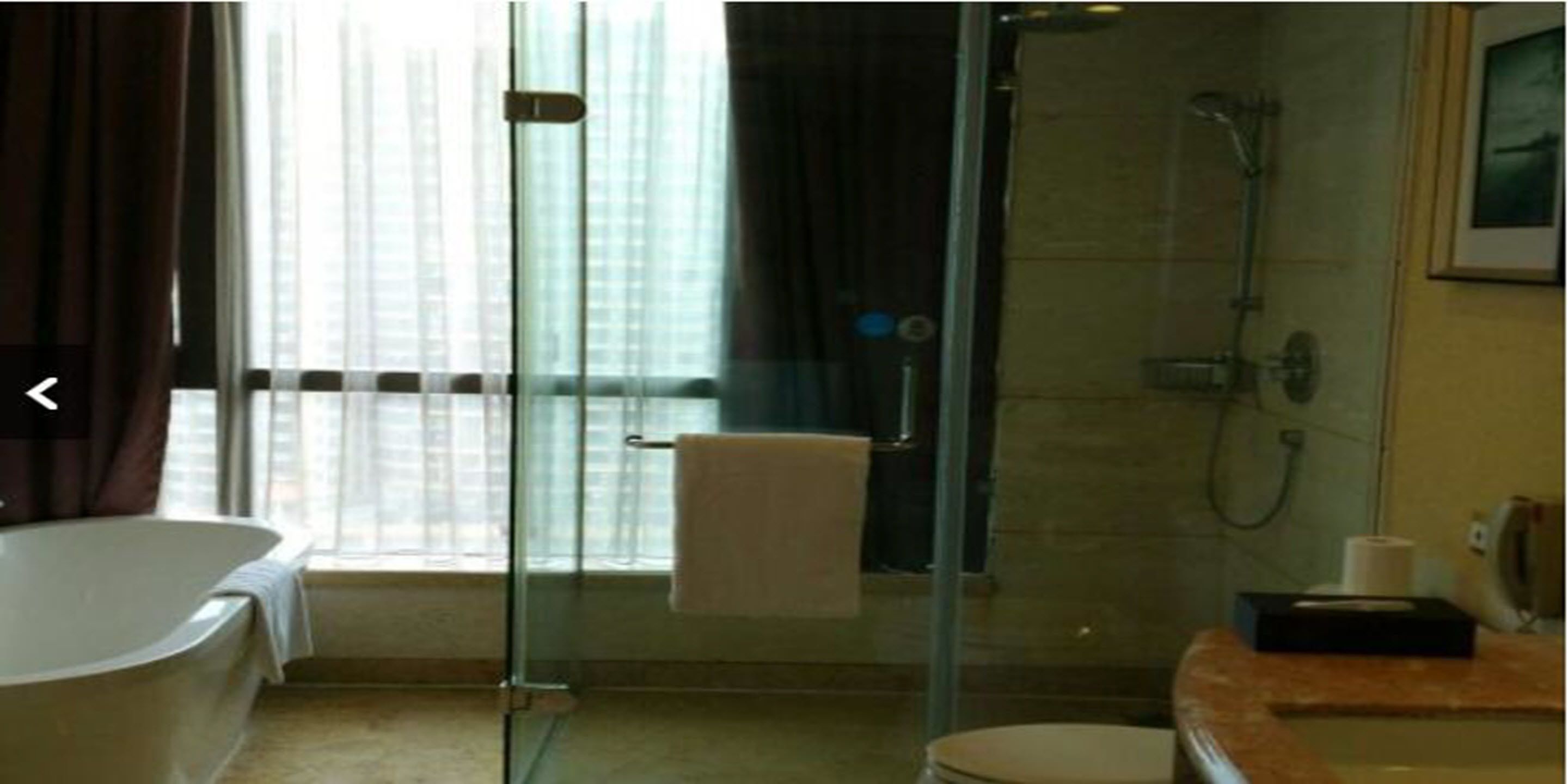 A modern bathroom with a glass-enclosed shower, a bathtub, and a vanity with a mirror.