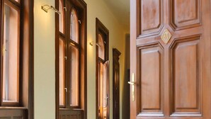 A hallway with wooden doors and light fixtures. - George Hotel (Lviv)