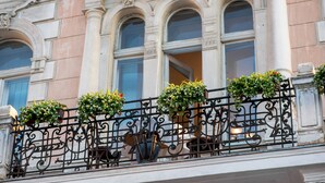 A building facade with ornate iron railings and multiple windows. - George Hotel (Lviv)