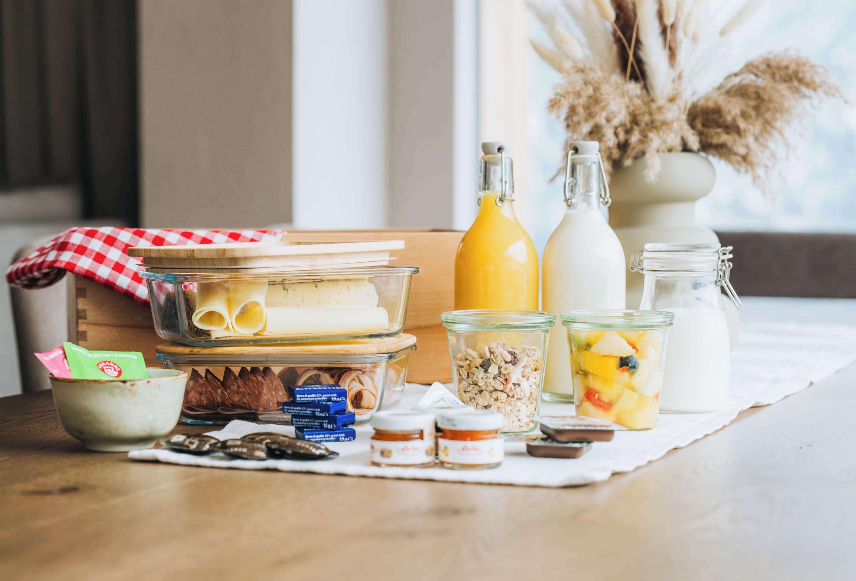 Una encimera de cocina con alimentos, frascos y una botella.