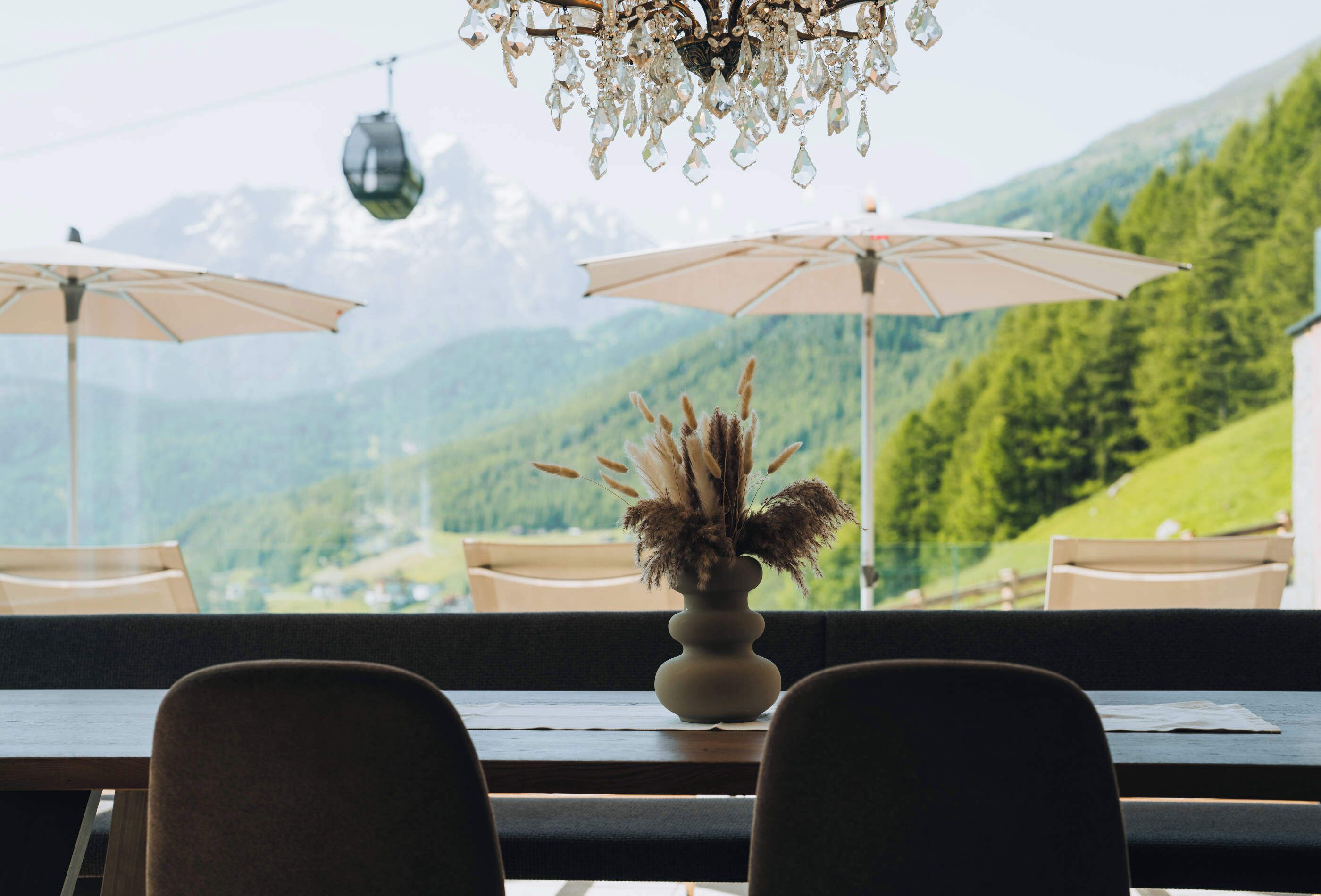 Un restaurante con vistas a las montañas, un candelabro y dos sombrillas.