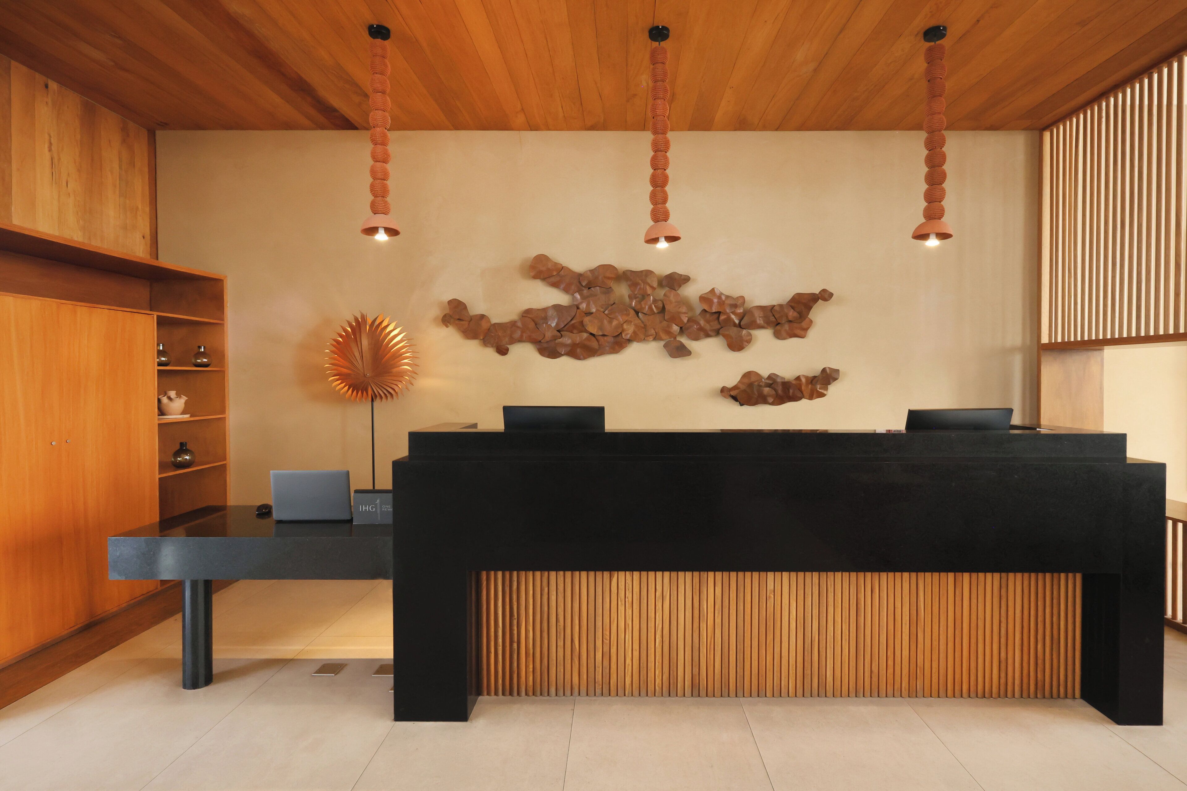 Una recepción con un ordenador portátil, estanterías de madera y una obra de arte original en la pared.