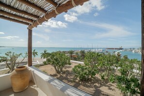Un balcón con vista a un puerto deportivo y una playa.