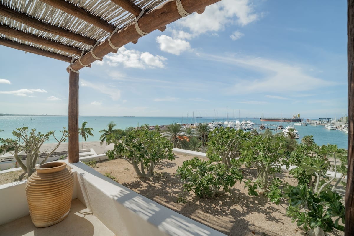 Un balcón con vistas a un puerto deportivo y una playa.