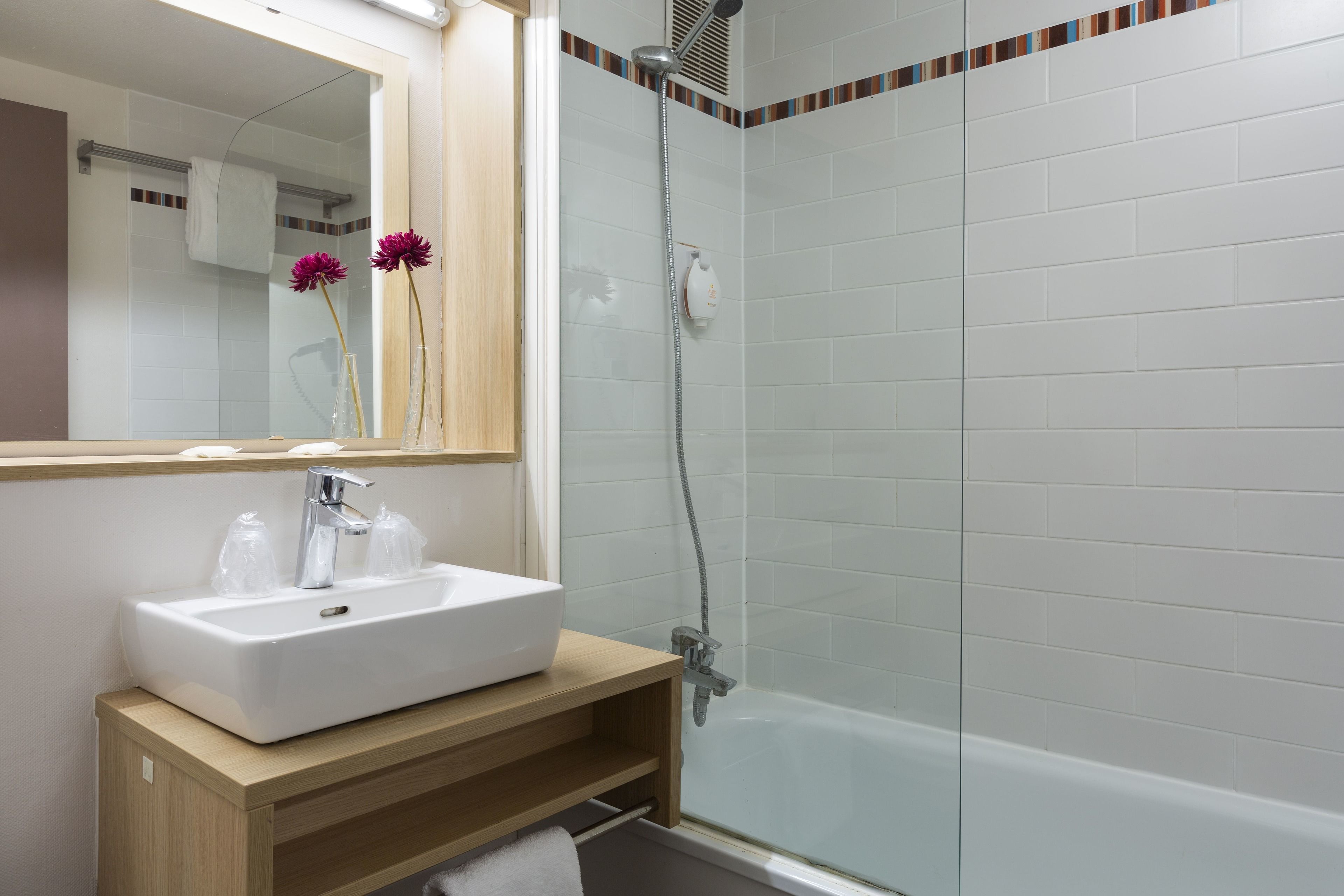 Een bad, milieuvriendelijke toiletartikelen, een haardroger, handdoeken