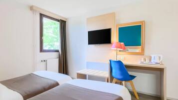 Une chambre d’hôtel avec deux lits, un bureau, une chaise, une télévision et une fenêtre avec des rideaux.