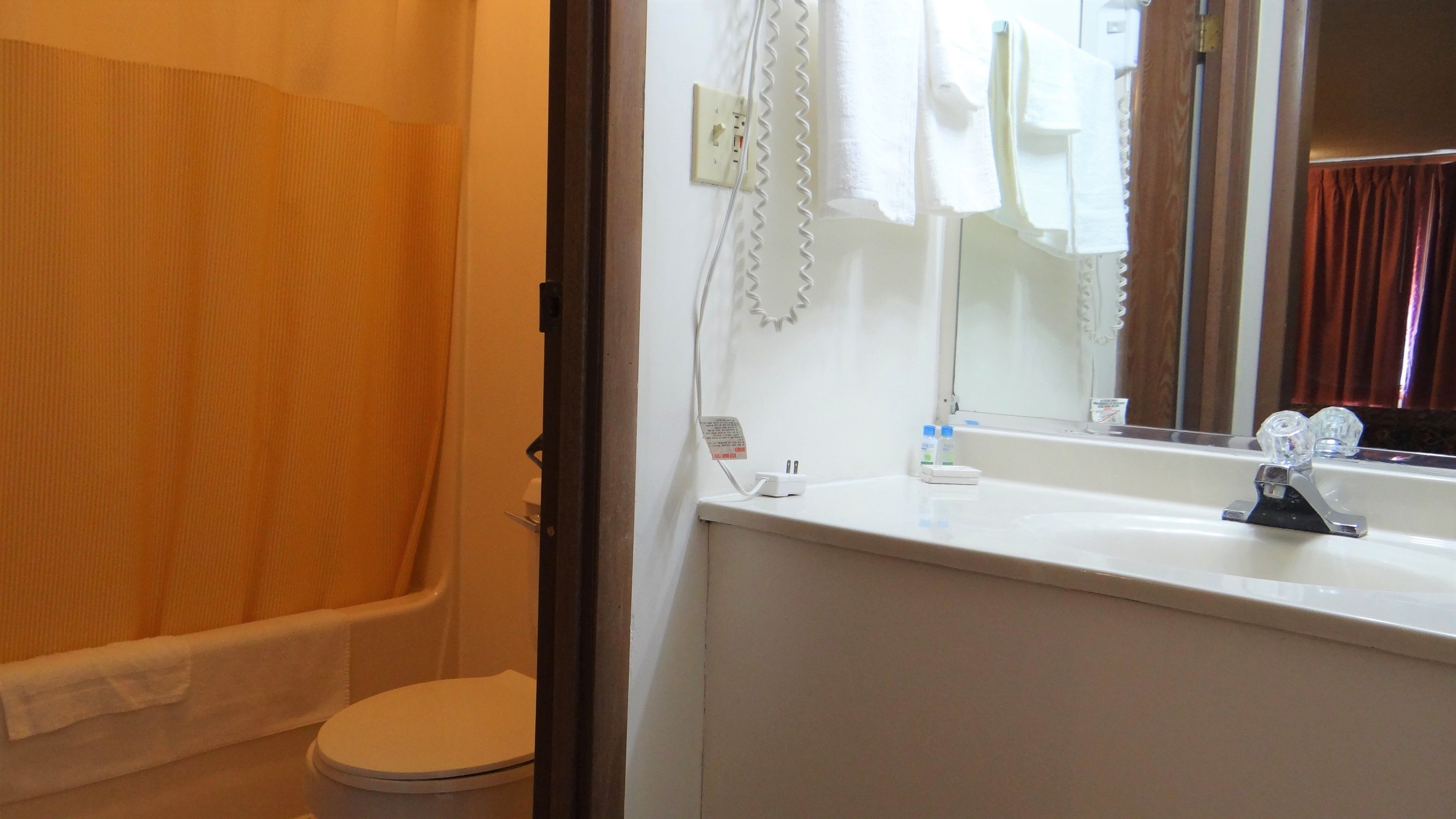 A bathroom with a bathtub, toilet, sink, and a mirror.