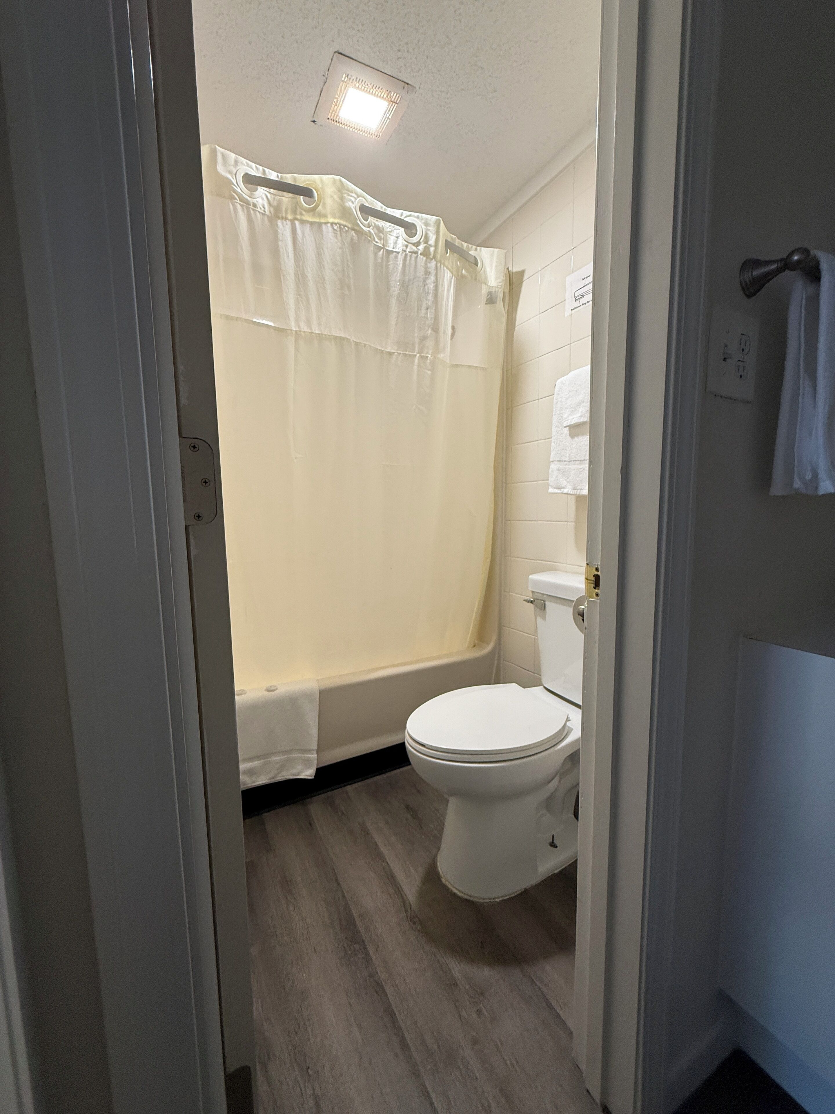 Une salle de bain équipée de toilettes, d’une baignoire et d’un rideau de douche.