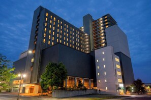 A multi-story hotel with a modern architectural design, featuring a prominent entrance and a large tree in front. - Iwaki Washington Hotel (Iwaki)