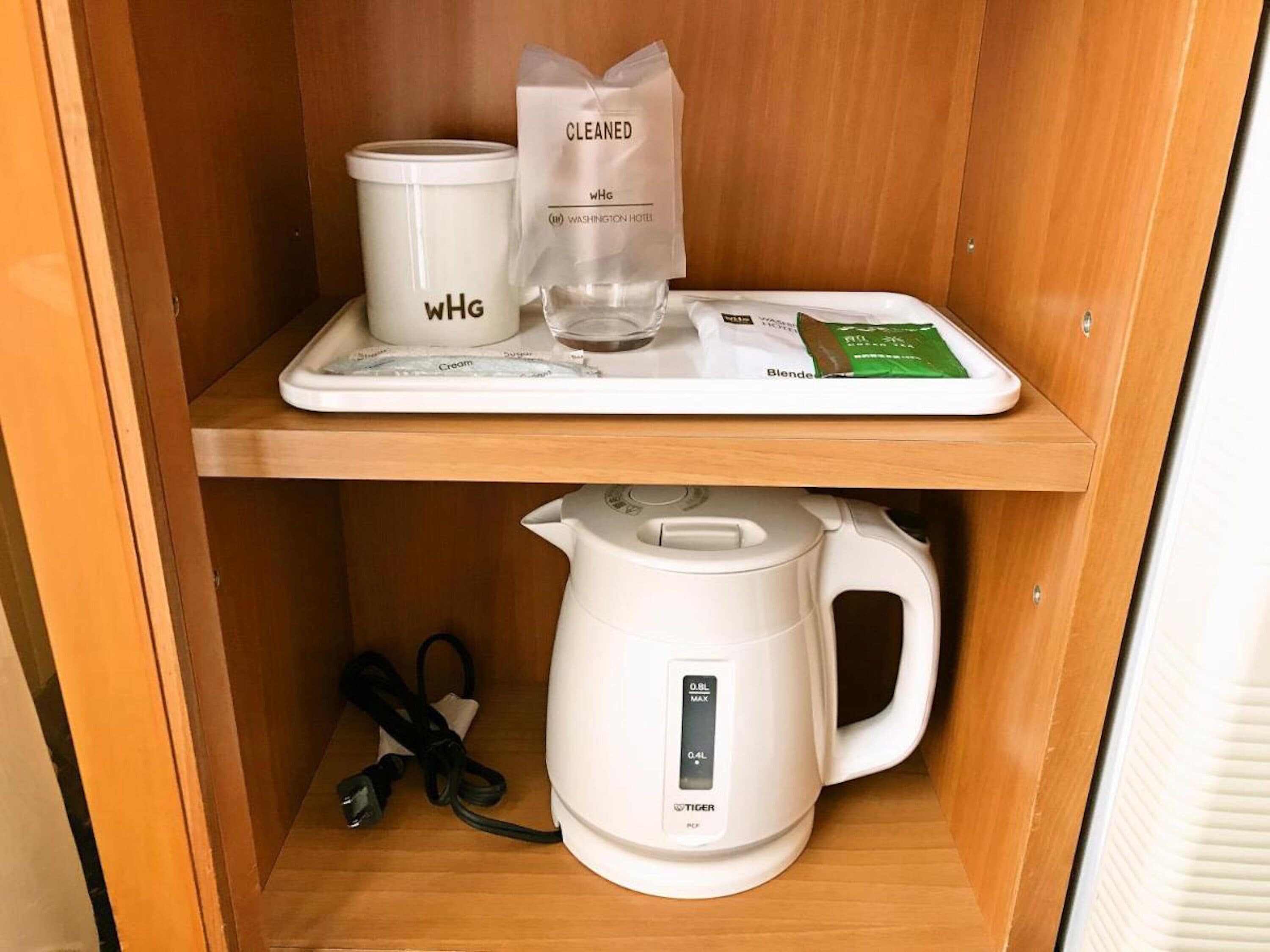 Un coin cuisine équipé d’une machine à café, d’un distributeur de crème et d’un sac étiqueté « NETTOYÉ ».