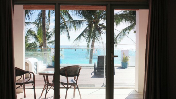 Habitación con vista a una piscina y palmeras.