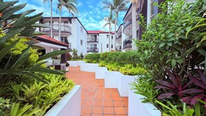 A pathway leading to a building with balconies and a red-tiled roof. - Santana Resort (Surfers Paradise)