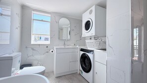 Bañera con ducha, secador de pelo, toallas, papel higiénico