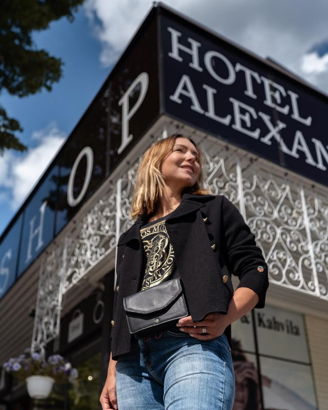 Uma pessoa em frente a um edifício com uma placa que diz 'HOTEL ALEXAN'.