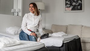 A hotel room with a bed, a sofa, a lamp, and a framed picture on the wall. - Hotel Alexander (Maenttae-Vilppula)