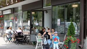 A cafe with outdoor seating, a sign reading "Cafe Alex," and a small Christmas tree with red flowers. - Hotel Alexander (Maenttae-Vilppula)